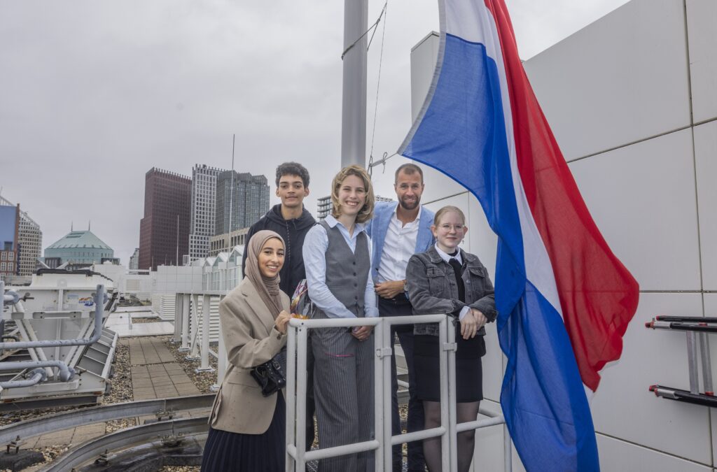 Geslaagde leerlingen hijsen de vlag en hun rugzak op stadhuis