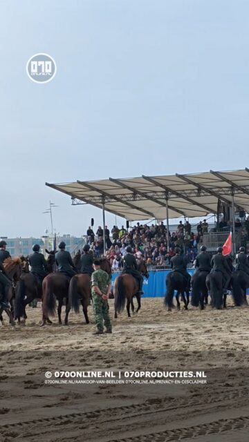 Cavalerie ere escorte oefent op het strand van Scheveningen.
Het is maandag 14 september 2026 een dag voor Prinsjesdag. Aan de kant van de pier komen de eerste paarden het strand op, richting Beach Stadium. Over ruim vierentwintig uur lopen dezelfde dieren mee in de koninklijke rijtoer door Den Haag.
Het Cavalerie Ere-Escorte oefent ieder jaar. Dit jaar ter hoogte van het Beach Stadium. De oefening is vrij toegankelijk — iedereen die toevallig langs het strand loopt, staat zo tussen het publiek. De zon schijnt, met af en toe wat bewolking.
Het publiek krijgt een taak. School(kinderen) mogen klappen en schreeuwen zo hard ze willen. Daarna klinkt er muziek: Trompetterkorps der Bereden Wapenen speelt om de paarden te testen. Twee landmachtmilitairen op crossmotoren trekken lijnen in het zand, een grens waarachter de menigte moet blijven.
De ochtend verloopt overwegend rustig de meeste paarden reageerden goed op het kabaal.
Na de oefening bij het Beach Stadium keert de stoet om en vertrekt weer via de kant van de pier, dezelfde weg terug.