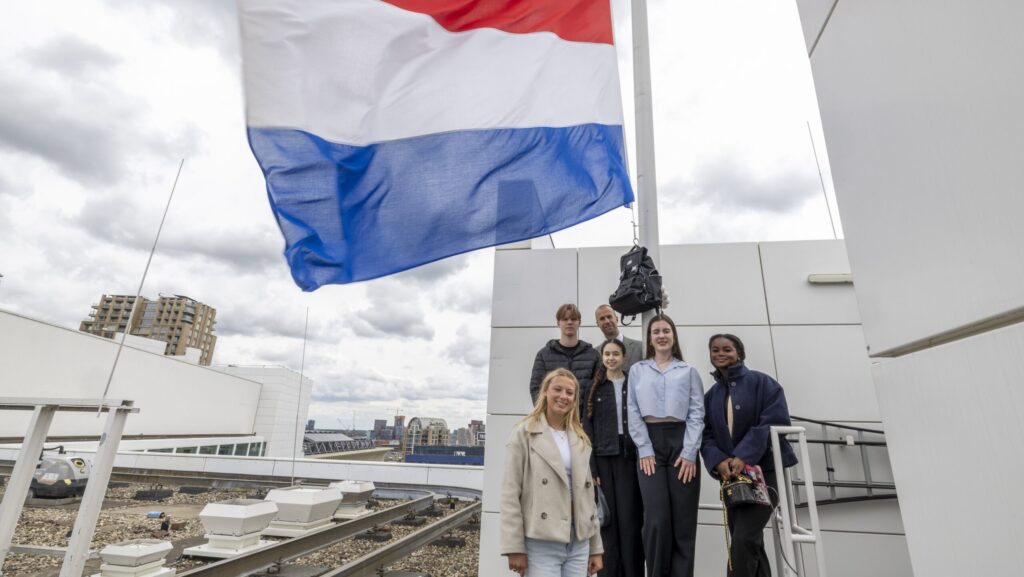 Geslaagde Haagse scholieren hijsen vlag op dak stadhuis